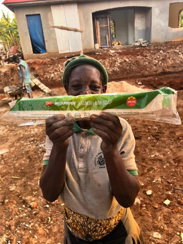 A customer in Kabuyanda holding a sleeved Jukye laundry bar